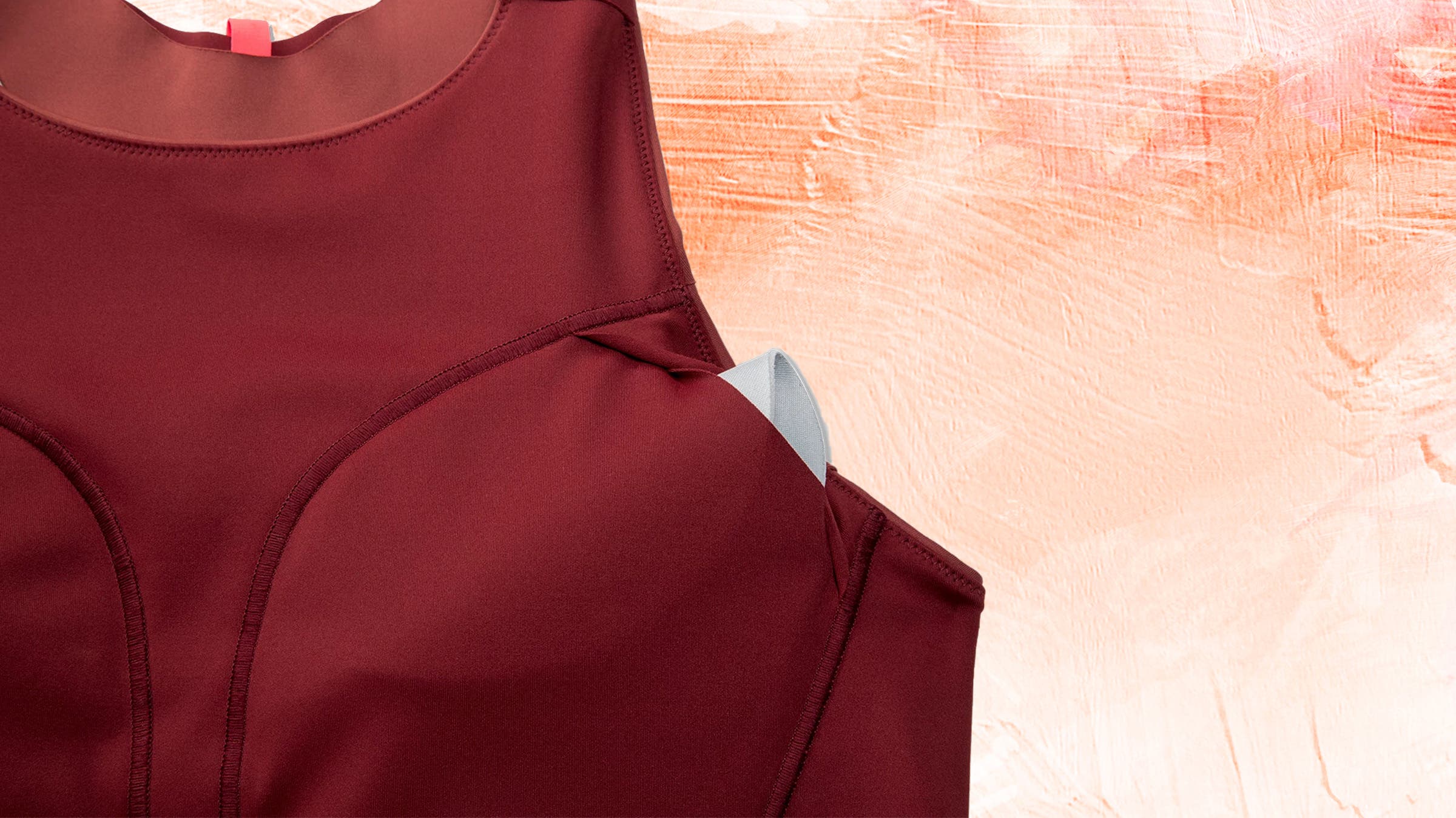 Sports bra with removable bra pad sticking out on top of a colorful background