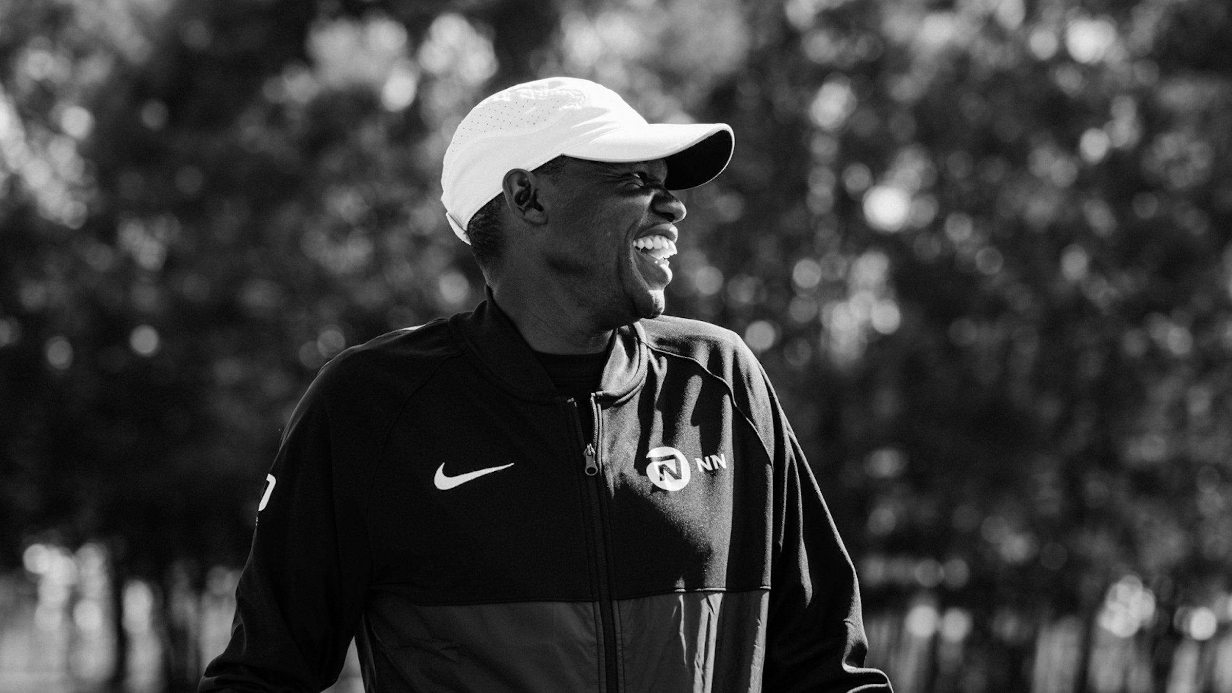 Patrick Sang laughing in a black and white frame