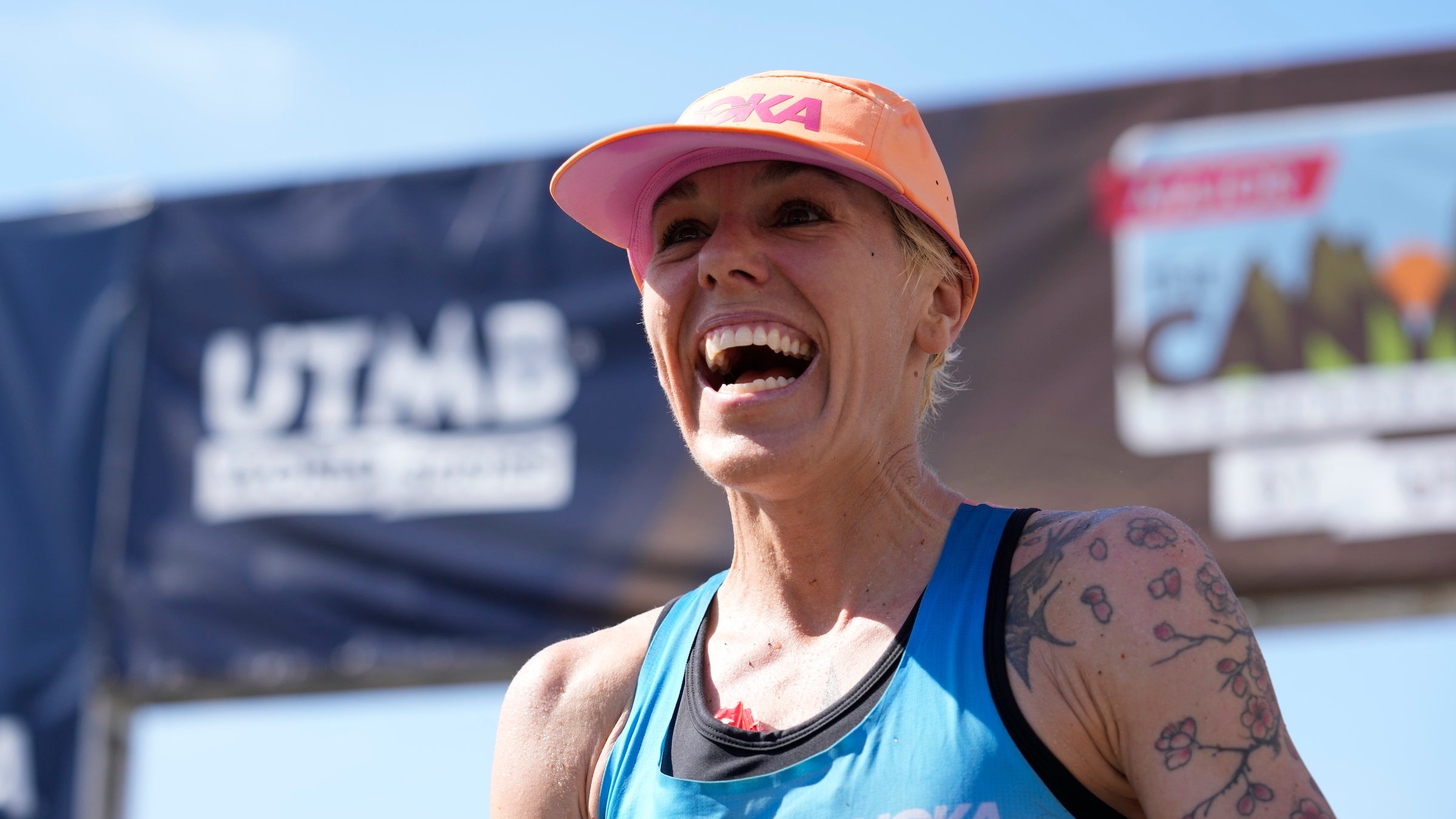 A woman wins a trail race with a pink hat one