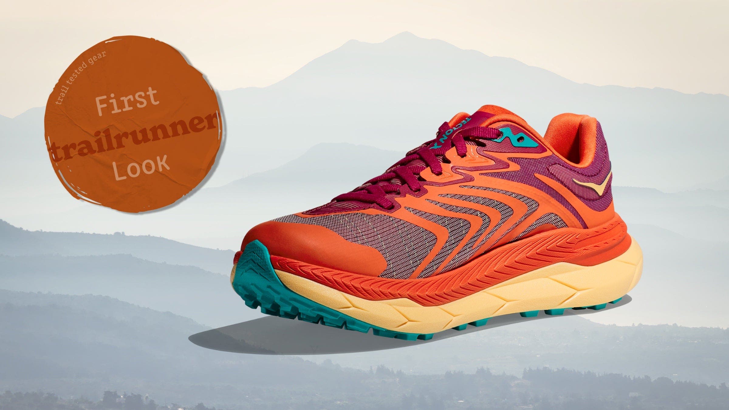 An orange trail shoe on a background of mountains