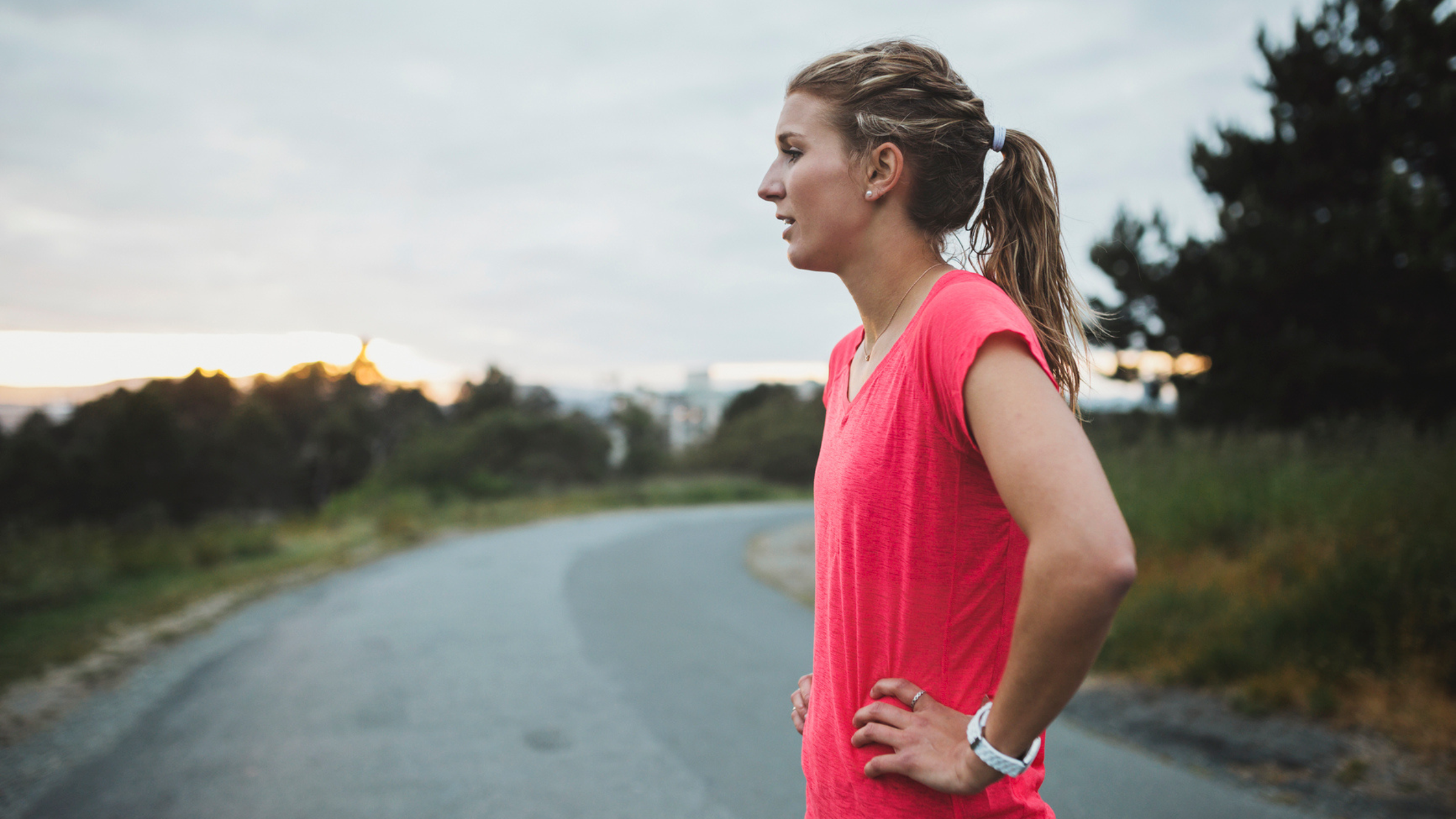 a woman looks out at a road after a run