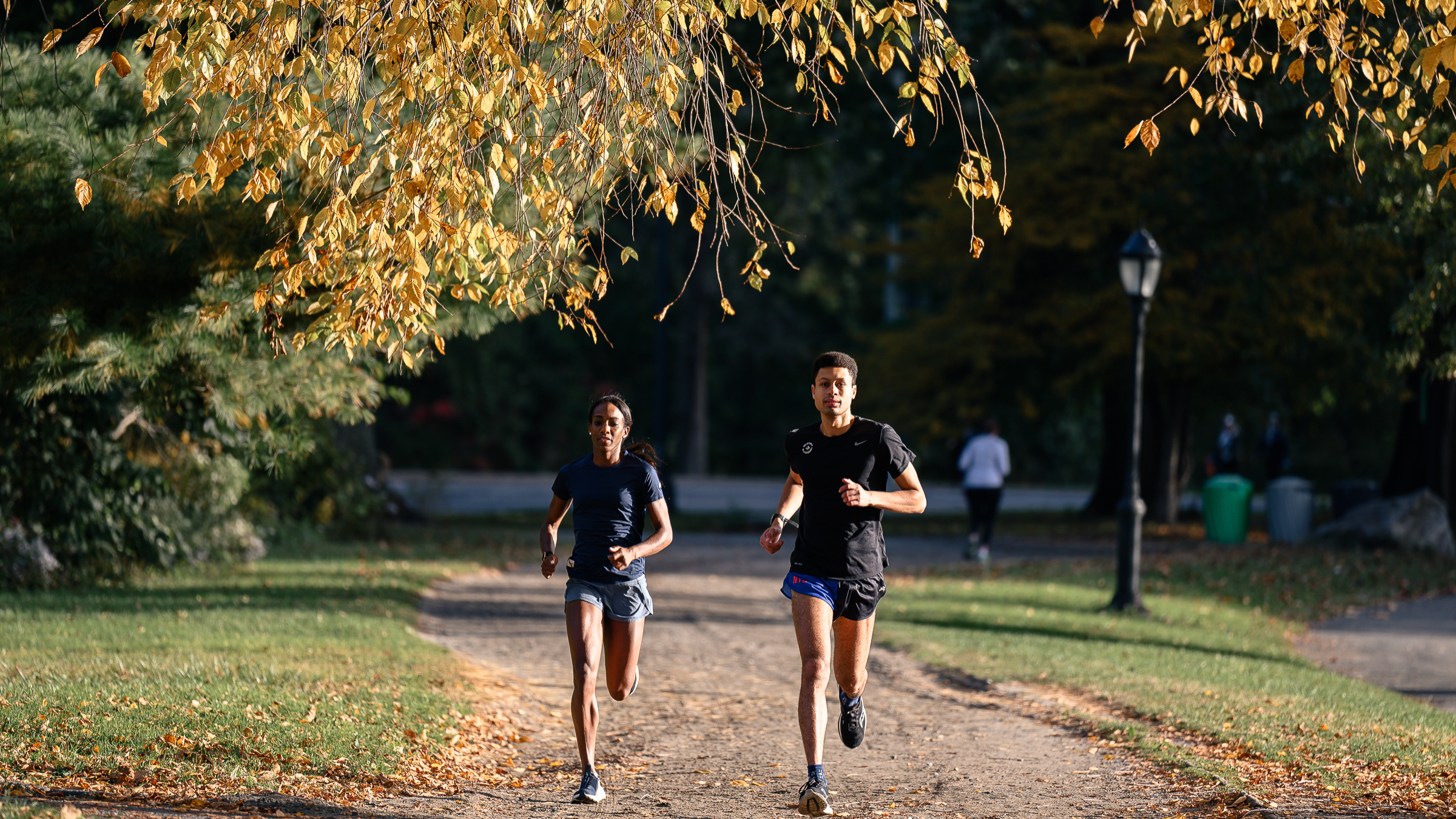 two smiling runners complete a running workout in New York City in the fall