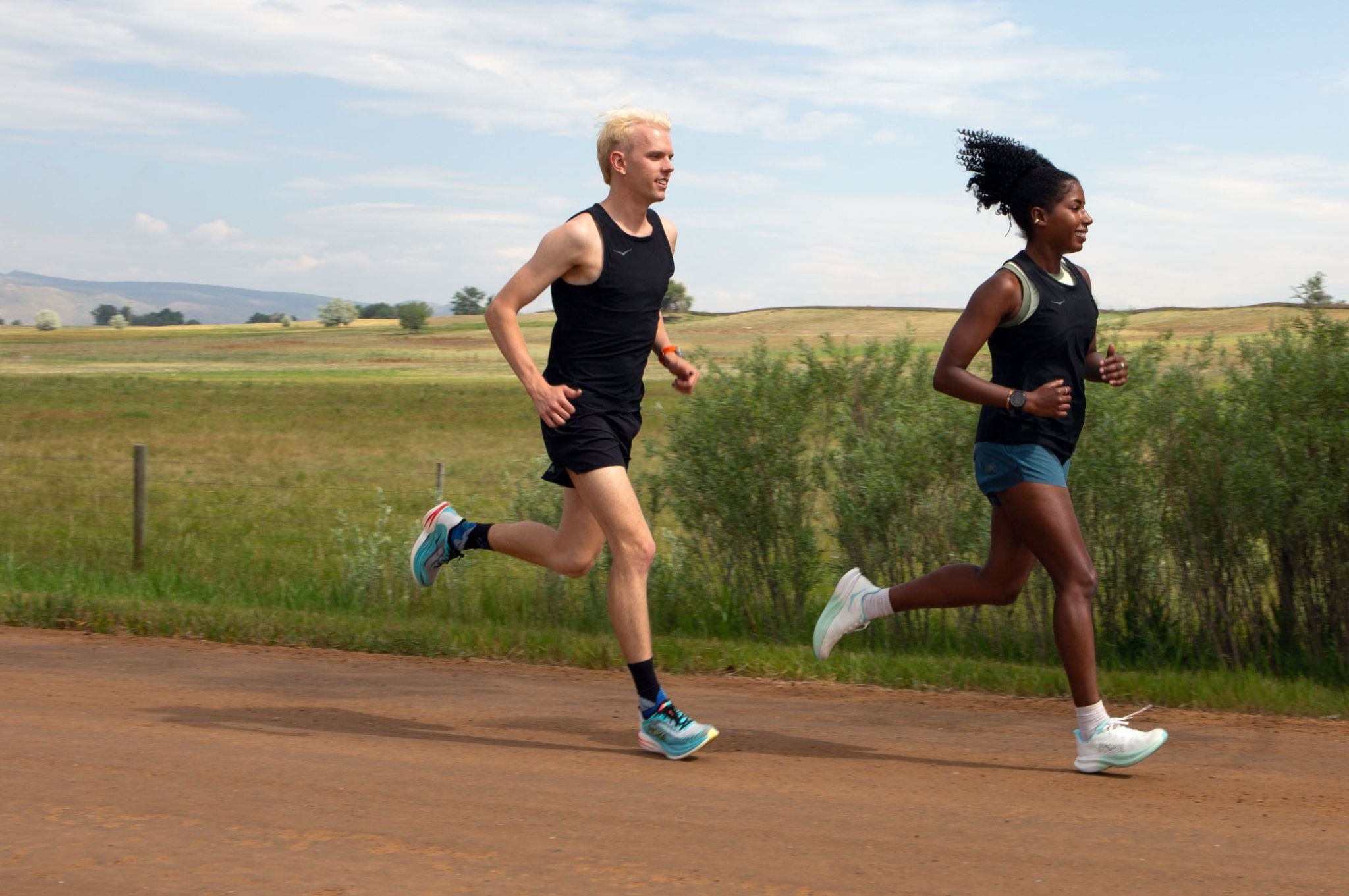 a man and woman run on a dirt road