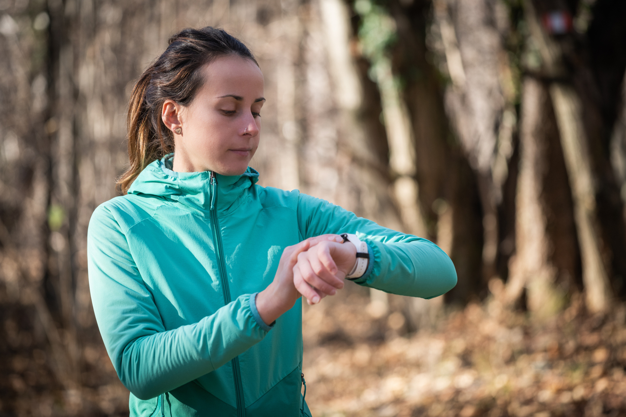 a woman checks her watch while running